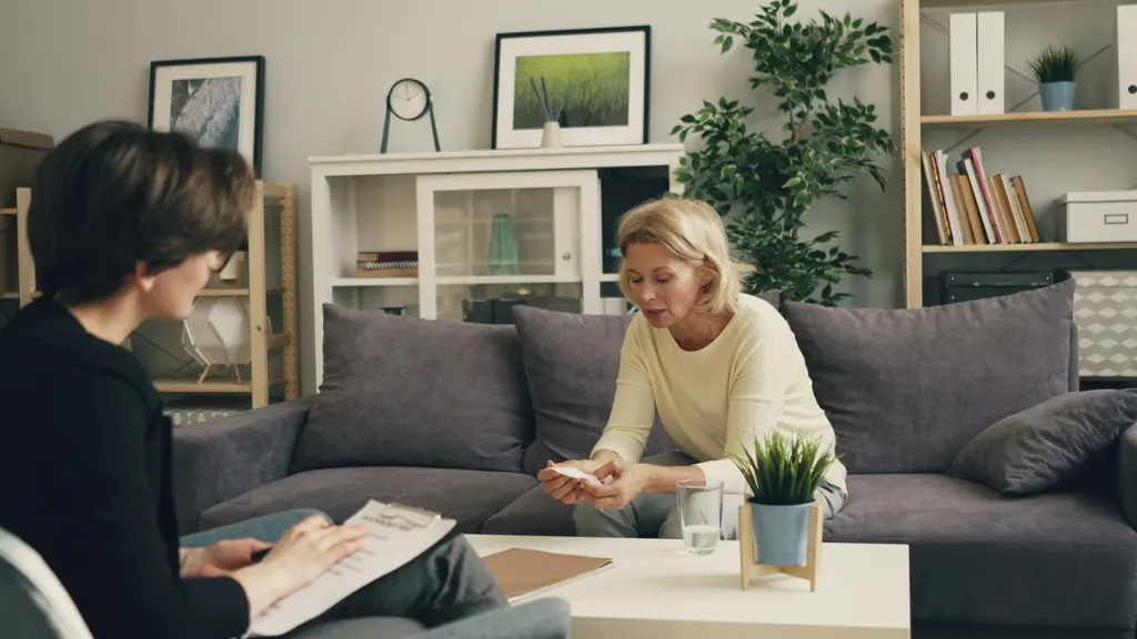 A care manager reviews a plan with an older woman in her living room